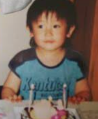幼少期の兼近大樹(かねちー)が誕生日ケーキの前に座っている昔の写真