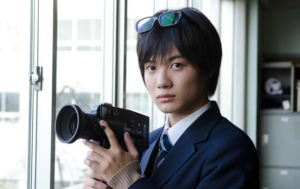 高校生役でカメラを構える制服姿の神木隆之介。日出高校時代を彷彿とさせるワンシーン