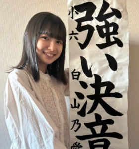 書道で「強い決意」と書き笑顔を見せる白山乃愛。小学校時代の習い事である書道の腕前を披露する様子。