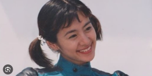 特撮ドラマ『超力戦隊オーレンジャー』出演時の、若々しくも凛々しい佇まいを見せるさとう珠緒。短めのツインテールを揺らし、微笑みを浮かべている。