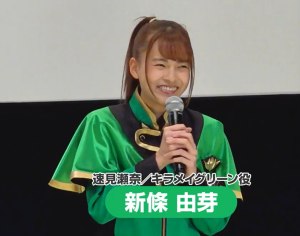 『魔進戦隊キラメイジャー』のステージ上で、満面の笑みを見せる新條由芽。鮮やかなグリーンの衣装が、彼女の持つ快活さと、アスリートらしいハツラツとした魅力を際立たせている。