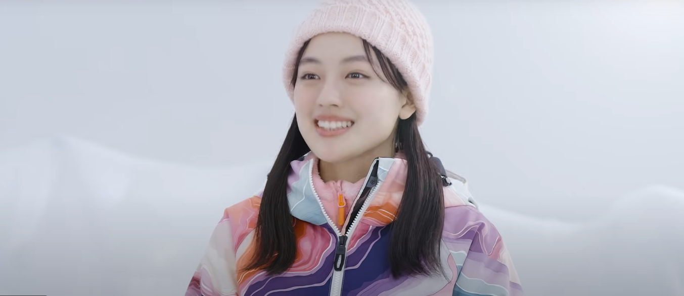 冬の屋外でピンクのニット帽とカラフルなスノーウェアを着用して微笑む、近年の上坂樹里