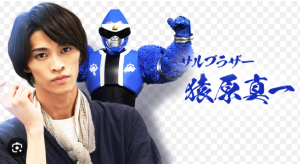 暴太郎戦隊ドンブラザーズに出演した俳優の別府由来（手前）と、彼が演じた青色のヒーロー「サルブラザー／猿原真一」（奥）。右側には青色で「サルブラザー 猿原真一」という文字。