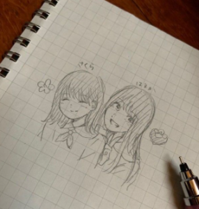 賀喜遥香が学生時代にノートに描いたと思われる、同期の遠藤さくらとの自筆イラスト。鉛筆で描かれた二人の絆。