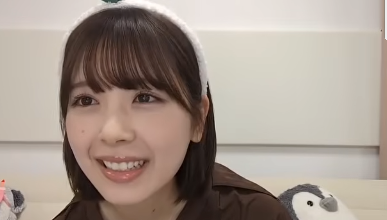 配信番組に出演し、白いヘアバンド姿で優しく微笑む乃木坂46・筒井あやめの近影。ナチュラルなメイクと透明感のある肌、穏やかな表情が印象的なバストアップのキャプチャ画像。