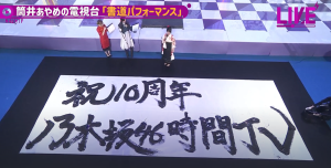 『乃木坂46時間TV』の企画「筒井あやめの電視台」にて、巨大な半紙に力強く「祝10周年 乃木坂46時間TV」と大筆で揮毫する書道パフォーマンスの様子。特待生の腕前を披露した際の引きの映像。