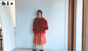 雑誌『bis』のファッション撮影で、赤いチュールスカートとゆったりとした赤いニットを纏い、アンニュイな表情を見せる乃木坂46の筒井あやめ。白背景に赤が映えるスタイリッシュな全身カット。