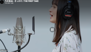 YouTubeチャンネル「THE FIRST TAKE」に出演した際の遠藤さくら。横顔のアングルで、ヘッドフォンを装着し、マイクに向かって乃木坂46の楽曲「きっかけ」を歌唱しているシーン。