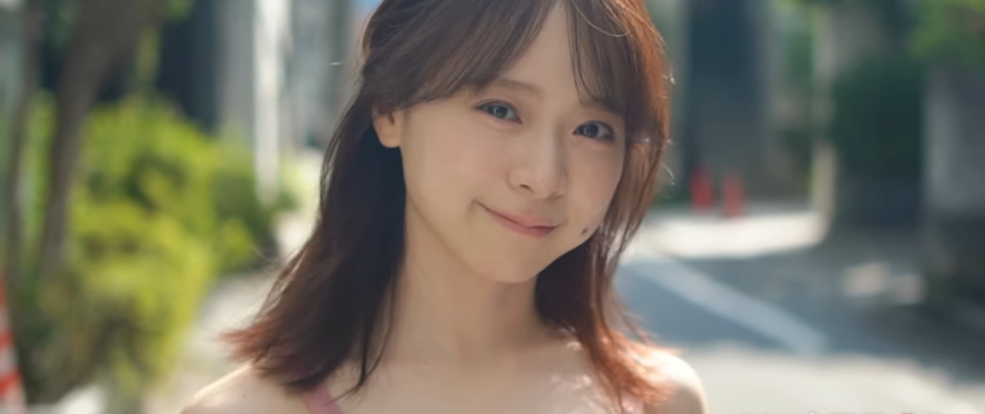 穏やかな笑顔を浮かべる倉野尾成美の顔のアップ写真。ノースリーブを着用し、ストレートヘアを耳にかけている。