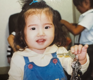 鍵の束を右手に持ち、無邪気に微笑んでいる幼い頃の村山彩希さんの写真