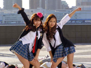 制服風の衣装でポーズをとるAKB48時代の河西智美（左）と板野友美（右）