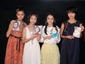 それぞれの顔写真がプリントされたパッケージ(DVDや写真集など)を手に持ち、横に並んで微笑む4人の若手女優たち(左から上白石萌歌、浜辺美波、上白石萌音、小川涼)