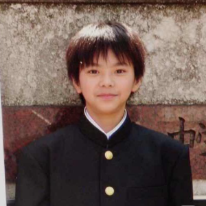 中学校の制服(黒の学ラン)を着用した学生時代の佐藤勝利。陸上部の部長としてストイックに打ち込んでいた中学生時代の一枚。