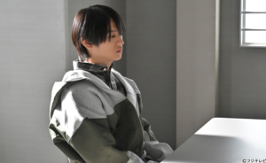 フジテレビ系ドラマ『東京P.D. 警視庁広報2係』のワンシーンで、取調室のような無機質な部屋に座る猟奇的な犯人役の猪俣周杜 。