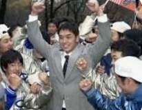 ドラフト会議での指名後、周囲からの祝福に笑顔で両腕を突き上げて応える若き日の阿部慎之助