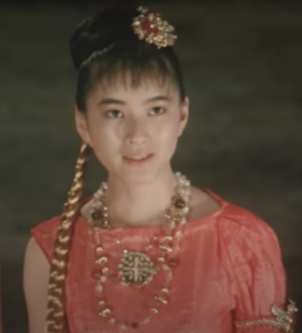 ピンク色の衣装と髪飾りを身につけた今村恵子