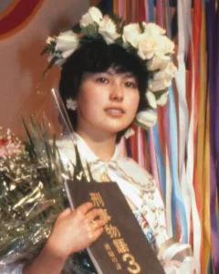 花の冠を被り、花束と映画「刑事物語3」の台本を抱えて微笑む沢口靖子