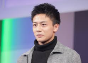 黒いタートルネックの上にチェック柄のジャケットを着て、未来を見据えるような真剣な眼差しを向ける齋藤璃佑