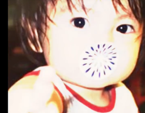 口元が花火のようなスタンプで隠された、くりくりとした目が愛らしい綱啓永の幼少期の写真