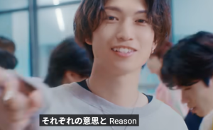 笑顔でこちらを指差す綱啓永。「それぞれの意思と Reason」という歌詞テロップが表示されたミュージックビデオのワンシーン
